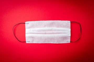 Obraz premium Medical mask on red background. Coronavirus disease COVID-19.