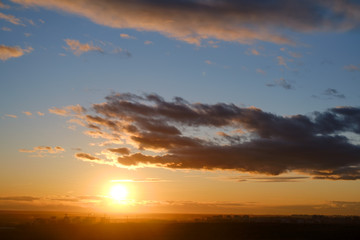 Fototapeta premium Orange sunset of the summer sun behind warm clouds