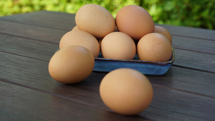 a pile of eggs on a plate and two eggs on the table with green background