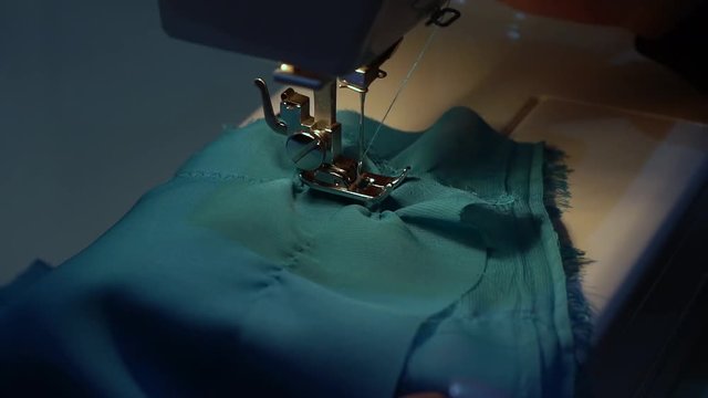 The girl unsuccessfully sews fabric on a neck machine.	