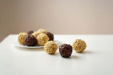 cakes, sweet dessert round shape chocolate and yellow are on a plate, a plate on a white table, three pieces of dessert are on the table