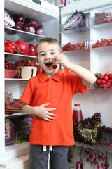 Content of refrigerator. Organic food. Red food in fridge, refrigerator. Healthy, dietary nutrition. Red vegetables, fruits, meat, fish, dishes. Color diet. Red products. Red color. Happy child, kid