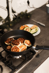 Pancakes are cooked in a pan. Cook breakfast in the kitchen. Breakfast with avocado