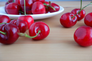 Cherries in a saucer on a wooden table. Suitable for background