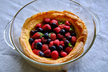 Dutch baby pancake with fresh strawberries, blueberries and raspberries
