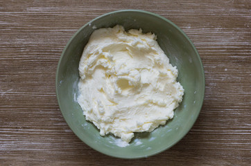 Top view of fresh homemade butter on plate on the wooden background