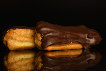 Sweet, mouth-watering chocolate eclairs, close-up, on a black background.