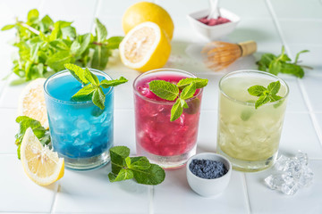 Selection of matcha lemonades - green, blue, red on white background, copy space