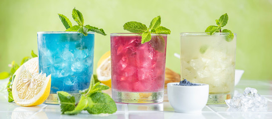 Selection of matcha lemonades - green, blue, red on white background, copy space