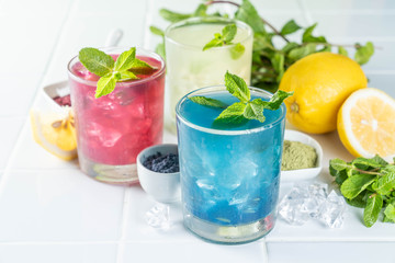 Selection of matcha lemonades - green, blue, red on white background, copy space