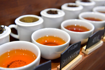 Tea of plant and flowers on white cup.