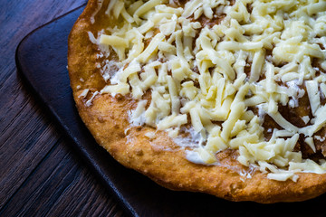 Traditional Langos / Langosh are originally Hungarian fried pancakes made from yeast dough, topped with Parmesan cheese and Mild Cream Cheese / Pisi.