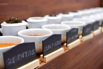 Tea of plant and flowers on white cup.