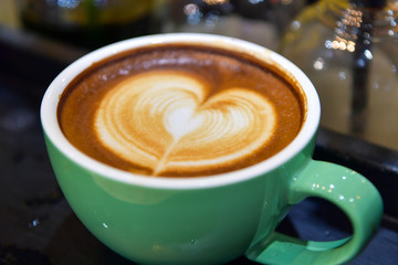 Shapes of art coffee on black cups.