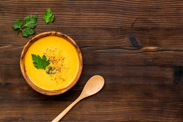 Pumpkin soup on wooden background top view space for text