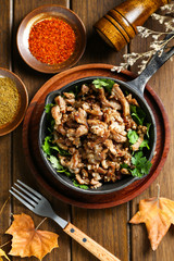 cumin fried lamb in pot on wooden table