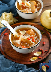 White fungus soup and pear in white bowl on wooden plate