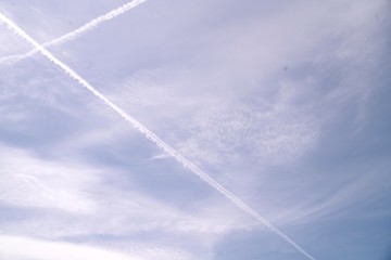 Fototapeta na wymiar Ciel bleu parsemé de nuages avec un avion qui est passé