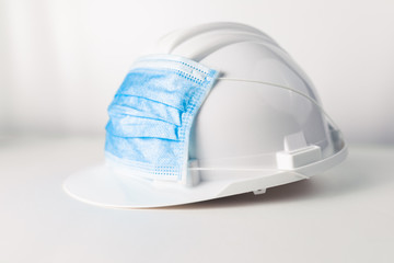 Ingegnere lavora durante il coronavirus con caschetto bianco e mascherina