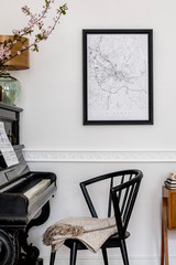 Stylish composition at living room interior with black piano, design chair, black mock up poster map, spring flowers, lamp, furniture and elegant presonal accessories in modern home decor.