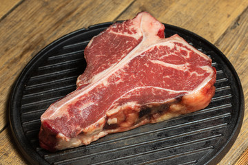 Thick Raw T-Bone Steak with Seasoning and Rosemary