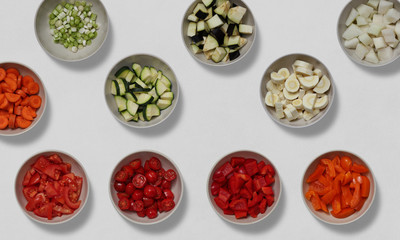 Bowls of cut vegetable pieces on a white background