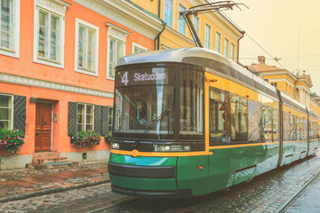 Green tram transporting people in the central part of the Helsinki city, Finland