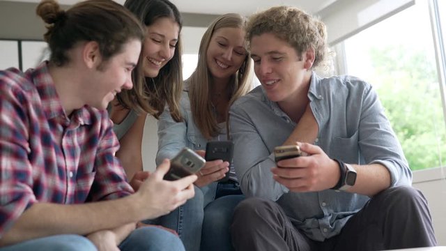 group of four young people with their phone
