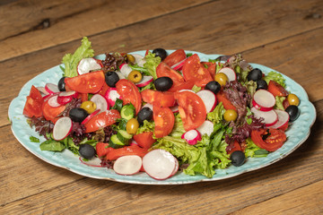 salad with vegetables and greens on wooden table