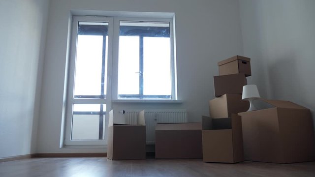 Stack of cardboard boxes for moving in interior apartment, movement or real estate concept. No people in empty room