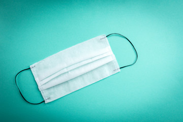 Medical protective mask on green background. Coronavirus COVID-19 quarantine.