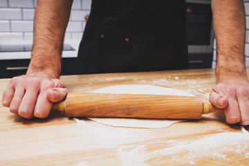 Close up shot of man's hands rolling dough
