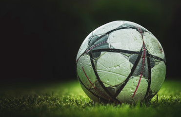 soccer ball on green grass and dark background