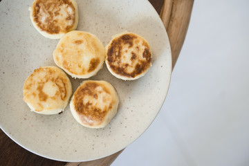 cottage cheese pancakes on a white plate on a wooden table