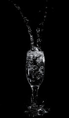 Splashes and drops of water in a glass are isolated on a black .