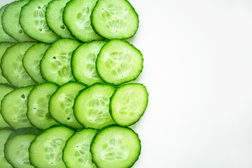 Cucumber slices are arranged in a row on a white background