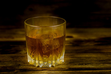Glass of whiskey on the dark wooden background