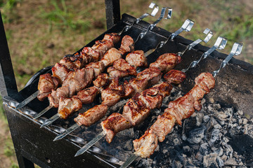 Shish kebab from a pork neck on skewers is prepared on coals in the grill