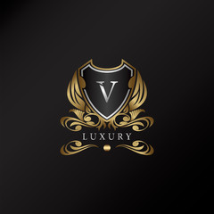 Shield logo in gold color with letter V Logo. Elegant logo vector template made of wide silver alphabet font on shield frame ornate style.
