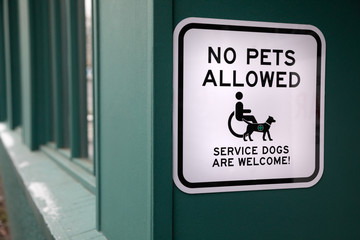 "No Pets Allowed. Service Dogs Welcome" sign at the entrance to a building