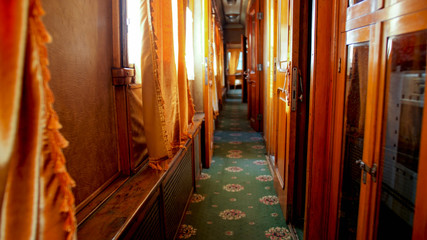Interior of old wooden train wagon with wooden walls and carpets on floor