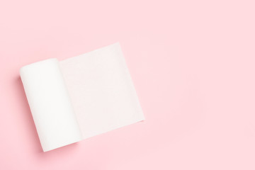 Roll of paper towels on a pink background. Concept is 100% natural product, delicate and soft. Flat lay, top view. Banner
