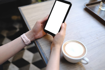 Businesswoman using mobile cell phone with touch screen in cafe. Sharing messages on social media.