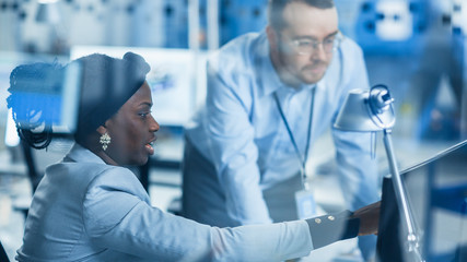 Modern Factory: Male Project Supervisor Talks to a Female Industrial Engineer who Works on Personal...