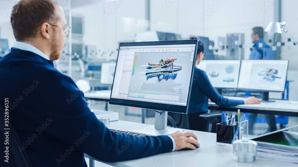 Aufkleber Over Shoulder: Heavy Industry Engineer Working on Personal Computer, Screen Shows CAD Software Showing New Generation Electric Engine. Industrial Factory with High-Tech CNC Machinery