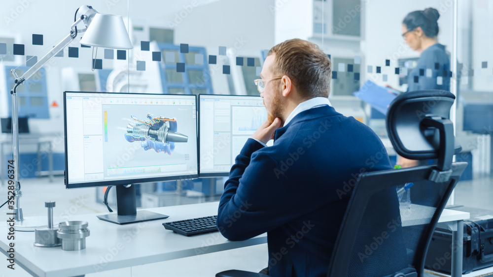 Fototapete Industrial Engineer Working on a Personal Computer, Two Monitor Screens Show CAD Software with 3D Prototype of Hybrid Electric Engine and Charts. Working Modern Factory.