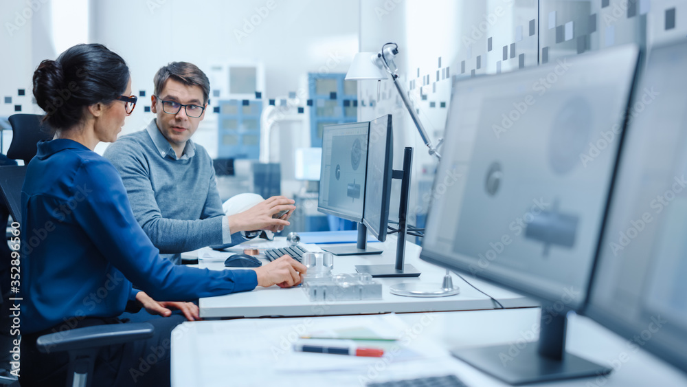 Poster Modern Factory: Male Industrial Engineer Explains to Female Project Supervisor Functions of the Machine Part Comparing it to one on Computer Screen. They use CAD Software for Design, Development