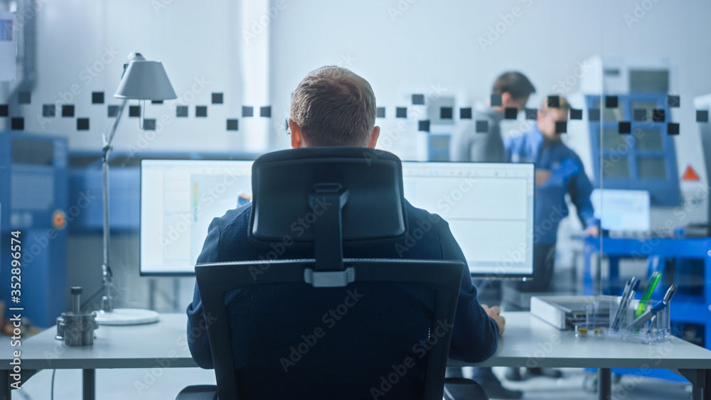 Poster Male Industrial Engineer Solving Problems, Working on a Personal Computer, Two Monitor Screens Show CAD Software with 3D Prototype of Zero-Emissions Engine Being Tested. Back View