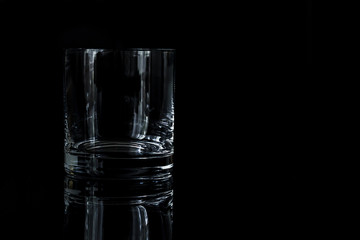 one glass for whiskey on a black background