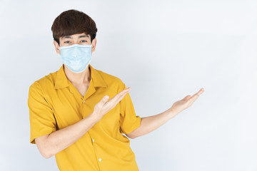 Asian handsome happy hipster man wearing a medical protection face mask for protect the...